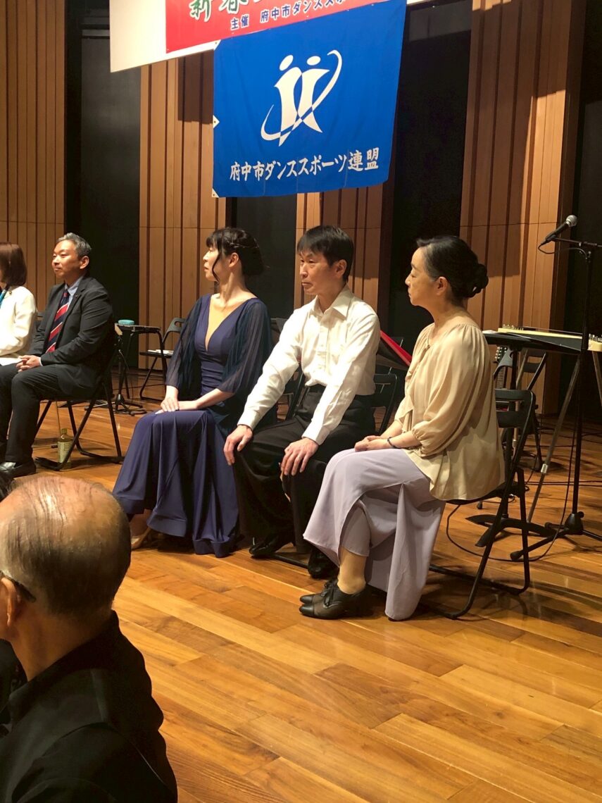 府中市ダンススポーツ連盟 新春ダンスの集いに参加した関係者の記念撮影。華やかなドレス姿が印象的